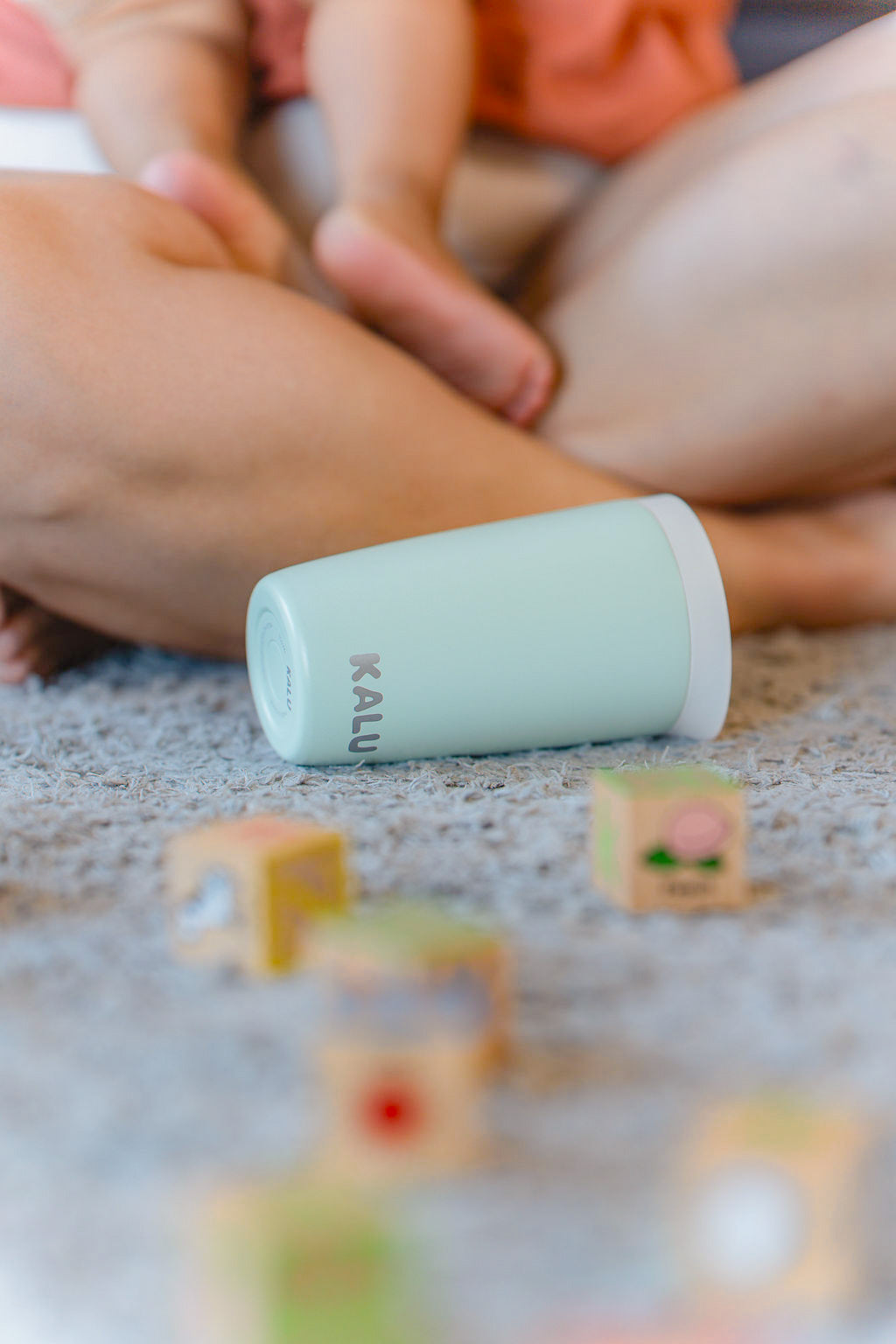 KALU Seafoam Green ceramic cup on floor with child's toys – reusable travel cup NZ